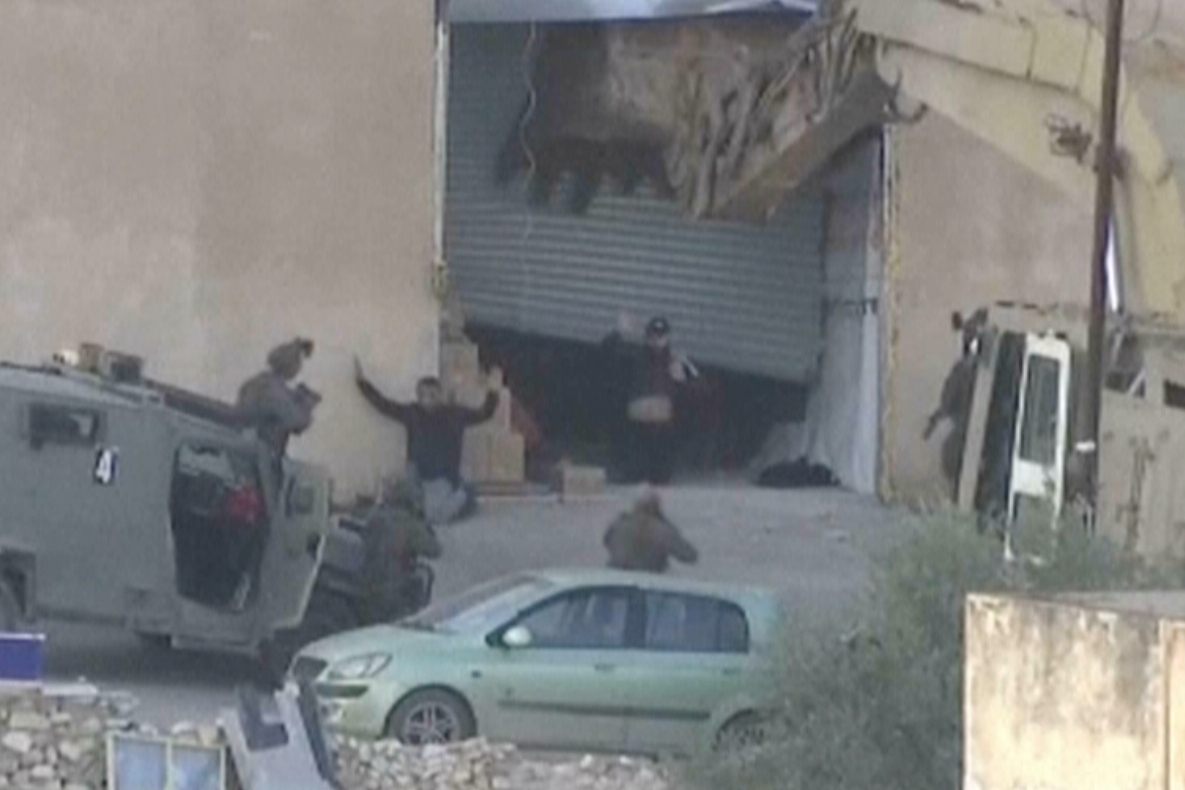 This image taken from video by Palestine TV shows two Palestinian men kneeling on the ground to Israeli forces shortly before they were shot dead during a military operation in Jenin, West Bank, on Thursday, Nov. 27, 2025.